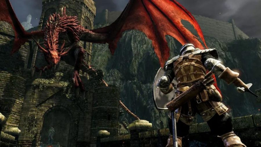 Um cavaleiro de Dark Souls enfrenta um wyvern vermelho gigante em uma ameia no final de uma ponte de pedra.