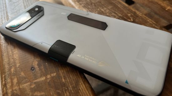 como-nós-testamos-4 Como testamos - um fundo branco e preto de um telefone, todo angular, sobre uma superfície de madeira.