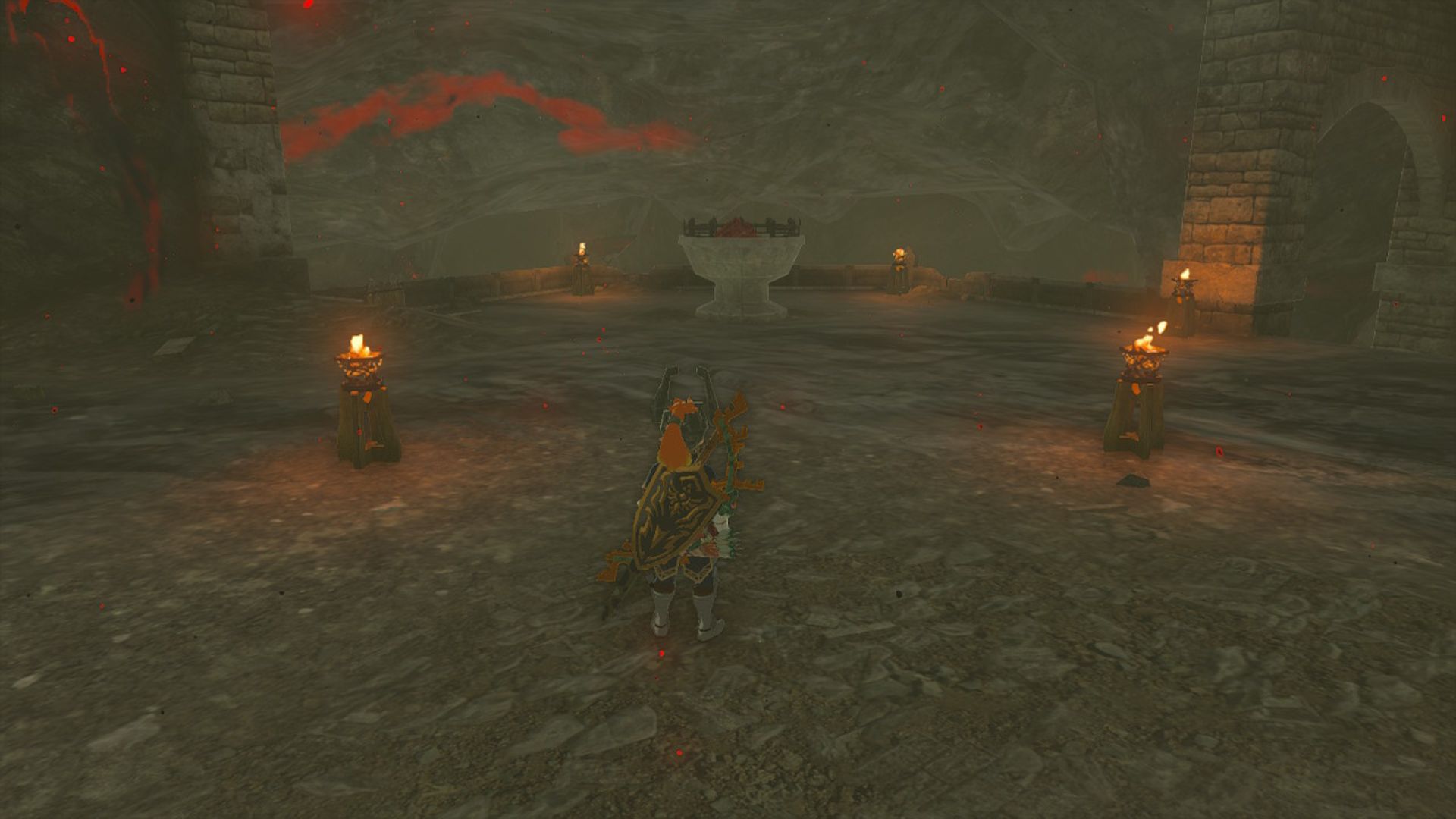 Zelda: Tears of the Kingdom Escudo Hyliano - Link, um garoto loiro em uma armadura ornamentada com armas nas costas, estava em uma plataforma/aterrissagem de paralelepípedos com quatro pequenas tochas em um quadrado ao redor de um grande braseiro no meio.