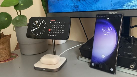 iphone-vs-samsung-2 iPhone x Samsung: qual é melhor para jogos? imagem de cabeçalho mostrando dois telefones, o iPhone 13 e o Samsung S23 Ultra. Ambos são pretos, mostrando suas telas, com relógio e calendário no iPhone na horizontal em um suporte, o samsung na vertical com a tela de bloqueio aparecendo.