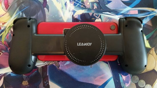 leadjoy m1 3 Revisão do LeadJoy M1: a parte de trás do controlador LeadJoy M1 conectado a um iPhone SE vermelho, mostrando a placa de resfriamento. Isto está em um mousemat Genshin Impact.
