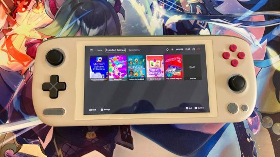 Análise do Ayaneo Air 1S: O Ayaneo deitado em um tapete de mouse Genshin Impact, exibindo a tela do AyaSpace 2 com uma variedade de jogos, incluindo Oxygen Not Included, Sticky Business e Muse Dash