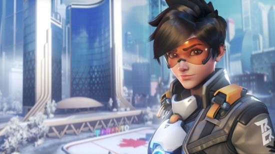 Lista de níveis Overwatch 2 - Personagens Tracer e Overwatch 2, em frente a um fundo de paisagem urbana.  Eles têm cabelo preto curto, óculos laranja e uma roupa branca e preta