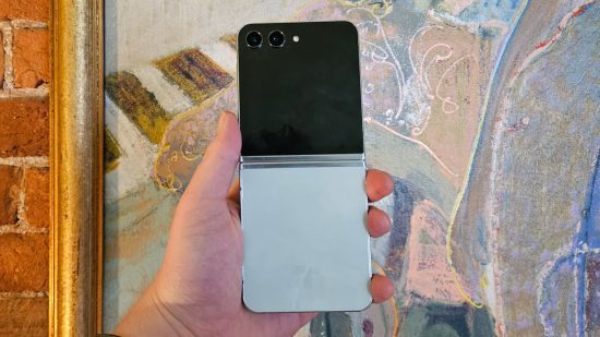 Cabeçalho do Samsung Galaxy Z Flip5 mostrando a parte de trás do telefone desdobrada na mão de uma pessoa em frente a uma imagem abstrata de uma mulher.