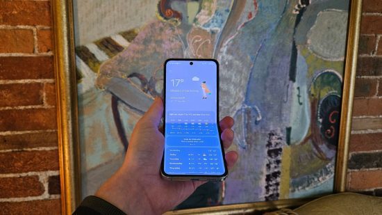 Cabeçalho do Samsung Galaxy Z Flip5 mostrando o telefone meio dobrado com a tela no aplicativo de previsão do tempo na frente de uma imagem abstrata de uma mulher.