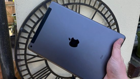 ofertas da apple na sexta-feira negra iPad-9-geração Ofertas da Black Friday da Apple - foto de análise do iPad 9 Gen, mostrando a parte traseira do iPad, em preto, enquanto ele é segurado no canto inferior direito.  A parte traseira é preta e metálica, com um logotipo preto da Apple no centro do dispositivo.